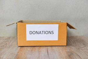 Donations box on wooden table background donate concept photo