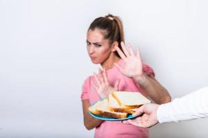 la mujer joven sufre de gluten. concepto de dieta intolerante al gluten y sin gluten, personas reales. copie el espacio intolerancia al gluten y concepto de dieta. mujer se niega a comer pan blanco. centrarse en el pan foto