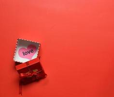 vista superior de la caja de regalo roja abierta con corazón de amor en la caja con fondo rojo - san valentín, cumpleaños, aniversario
