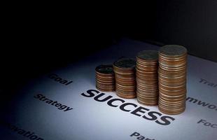 Finance and investment concept - Stack of coins on success word which surround with other factor to make success photo