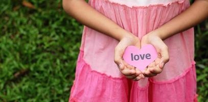 asimiento de la mano tarjeta de amor contra el fondo de la naturaleza foto