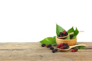 Group of mulberries on wooden table isolated on white background photo
