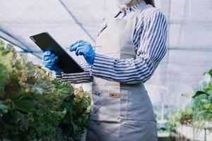 Futuristic businessman farms vegetables and crops using modern AI technology using mobile phones, temperature and humidity sensors, water tracking, climate control, holographic data data icons. photo