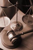 Justice and law concept.Male judge in a courtroom with the gavel, working with, computer and docking keyboard, eyeglasses, on table in morning light photo