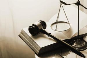 Justice and law concept.Male judge in a courtroom with the gavel, working with, computer and docking keyboard, eyeglasses, on table in morning light photo