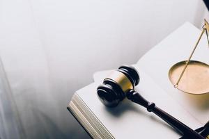 Justice and law concept.Male judge in a courtroom with the gavel, working with, computer and docking keyboard, eyeglasses, on table in morning light photo