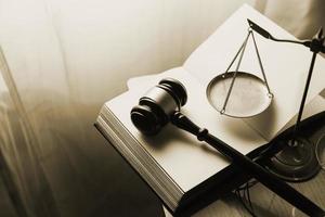 Justice and law concept.Male judge in a courtroom with the gavel, working with, computer and docking keyboard, eyeglasses, on table in morning light photo