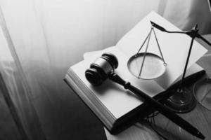 Justice and law concept.Male judge in a courtroom with the gavel, working with, computer and docking keyboard, eyeglasses, on table in morning light photo