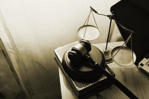 Justice and law concept.Male judge in a courtroom with the gavel, working with, computer and docking keyboard, eyeglasses, on table in morning light photo