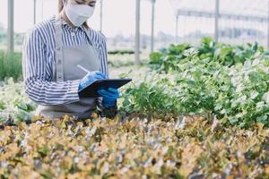 Futuristic businessman farms vegetables and crops using modern AI technology using mobile phones, temperature and humidity sensors, water tracking, climate control, holographic data data icons. photo