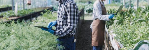 Futuristic businessman farms vegetables and crops using modern AI technology using mobile phones, temperature and humidity sensors, water tracking, climate control, holographic data data icons. photo