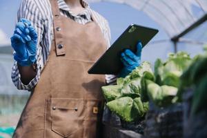 Futuristic businessman farms vegetables and crops using modern AI technology using mobile phones, temperature and humidity sensors, water tracking, climate control, holographic data data icons. photo