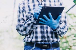 Futuristic businessman farms vegetables and crops using modern AI technology using mobile phones, temperature and humidity sensors, water tracking, climate control, holographic data data icons. photo