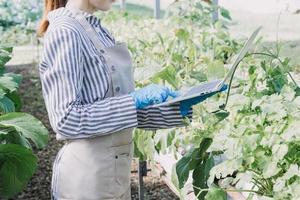 Futuristic businessman farms vegetables and crops using modern AI technology using mobile phones, temperature and humidity sensors, water tracking, climate control, holographic data data icons. photo