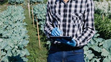 Futuristic businessman farms vegetables and crops using modern AI technology using mobile phones, temperature and humidity sensors, water tracking, climate control, holographic data data icons. photo
