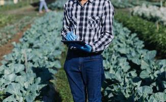 Futuristic businessman farms vegetables and crops using modern AI technology using mobile phones, temperature and humidity sensors, water tracking, climate control, holographic data data icons. photo