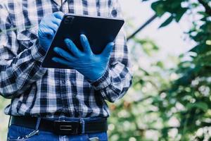 Futuristic businessman farms vegetables and crops using modern AI technology using mobile phones, temperature and humidity sensors, water tracking, climate control, holographic data data icons. photo