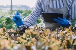 Futuristic businessman farms vegetables and crops using modern AI technology using mobile phones, temperature and humidity sensors, water tracking, climate control, holographic data data icons. photo