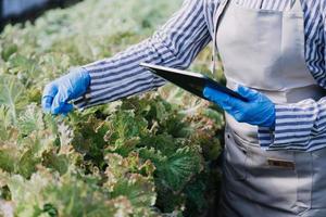 Futuristic businessman farms vegetables and crops using modern AI technology using mobile phones, temperature and humidity sensors, water tracking, climate control, holographic data data icons. photo