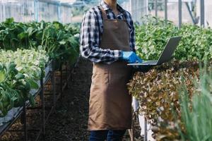 Futuristic businessman farms vegetables and crops using modern AI technology using mobile phones, temperature and humidity sensors, water tracking, climate control, holographic data data icons. photo