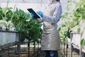 Futuristic businessman farms vegetables and crops using modern AI technology using mobile phones, temperature and humidity sensors, water tracking, climate control, holographic data data icons. photo