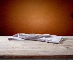 servilleta blanca, mantel sobre maqueta de cubierta de madera. foto