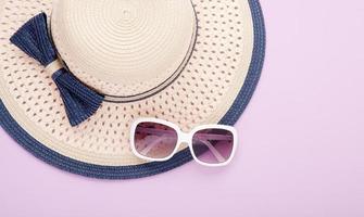 Summer hat with ribbon and sunglasses isolated on colorful background. Top view and copy space. photo