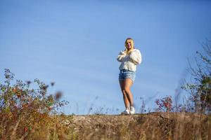 aerial view on girl stays on rock or concrete ruined structure on blue sky background as copy space photo