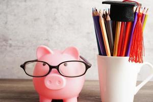 pigging bank usando anteojos con monedas y calculadora concepto de educación bancaria de ahorro. foto