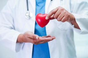 Asian woman doctor holding red heart for health in hospital. photo