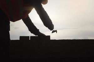 fondo instalando ladrillos en el sitio de construcción para hacer la casa. foto