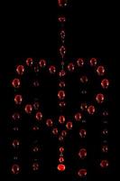 símbolo de un corazón llorando hecho de gotas de agua roja sobre un fondo oscuro, desenfoque de movimiento