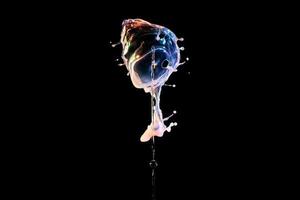 Falling drops of colored liquid, splashes on a black background, motion blur