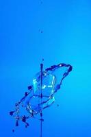 fondo abstracto de un chorro de agua coloreada, colisión de gotas coloreadas cayendo una hacia la otra. foto