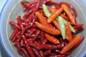 spicy green chilies and spicy red chilies with bowls background photo