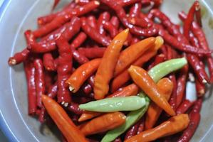 spicy green chilies and spicy red chilies with bowls background photo