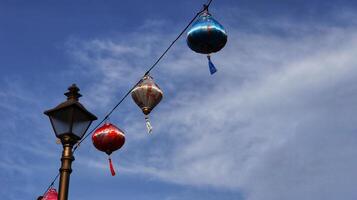 Colorful chinese lantern at hanging at the cable with blue sky background. photo