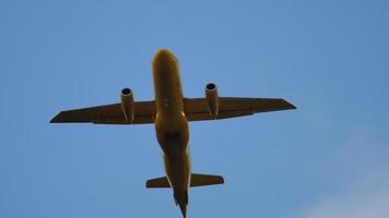 avión con librea amarilla vuela por encima. concepto de turismo y viajes. avión amarillo en el cielo azul brillante video