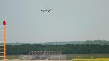 avião chega ao aeroporto, vista da pista. tiro longo, avião desce para pouso, vista da pista no aeroporto de dusseldorf dus. conceito de turismo e viagens aéreas video