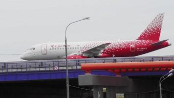 MOSCOW, RUSSIAN FEDERATION JULY 29, 2021 - Civil plane of Rossiya taxiing over Sheremetyevskoe highway. Airplane riding over bridge with traffic underneath video