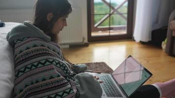 femme utilise un ordinateur portable sur le sol de la chambre video