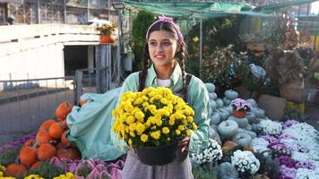 Woman holds mums and talks at fall market display video
