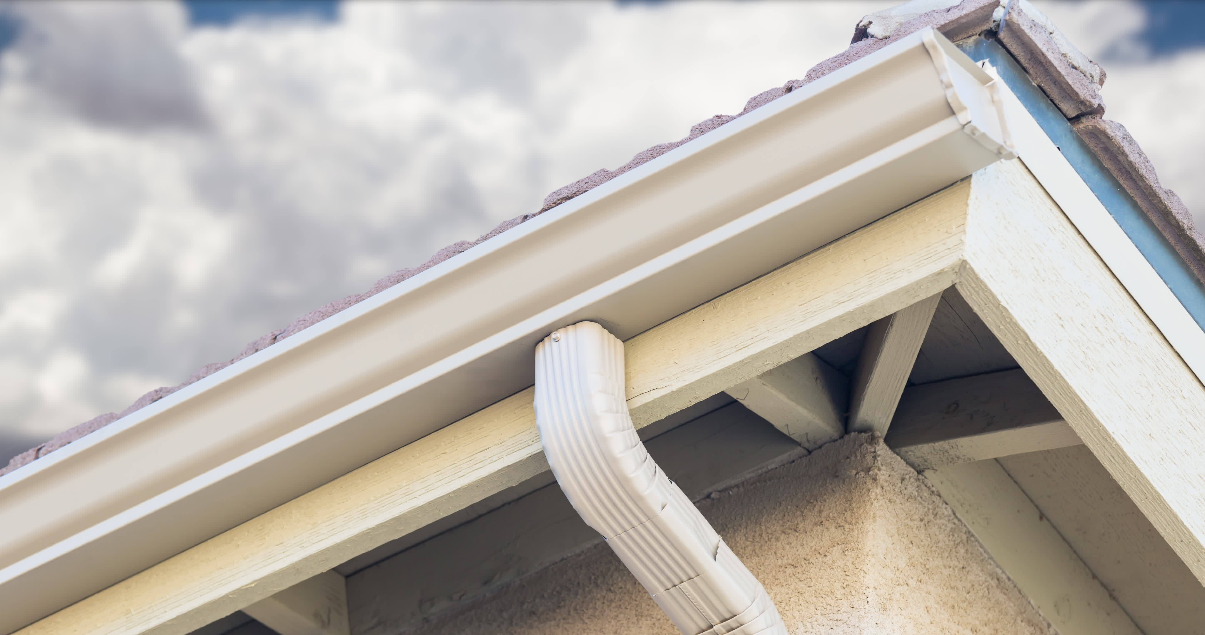 Rain Gutter and Drain Downspout with Time lapse Storm Clouds Behind ...