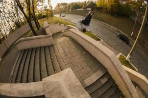 A young guy performs a side flip in the autumn park. The athlete practices parkour, training in street conditions. The concept of sports subcultures among youth photo