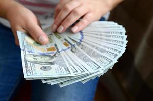 A girl holding a fan of dollar bills photo