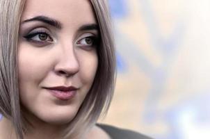 Portrait of a young blond girl with short hair on a background o photo