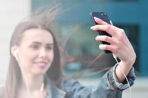 Young girl doing selfie on the background of an office building photo