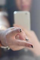 la chica morena toma fotos de sus dos dedos en un moderno
