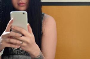 la chica morena se toma selfie en un teléfono inteligente táctil moderno foto