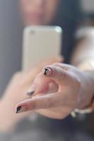 The brunette girl takes pictures of her two fingers on a modern photo